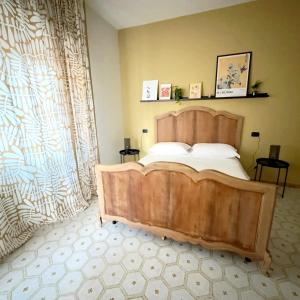 a bedroom with a wooden bed and a large window at TERRA DI SUD Matera - Free secure parking in Matera +4 photos