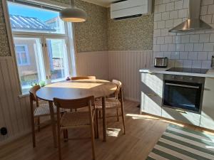 a kitchen with a table and chairs and a stove at Lönngården in Kristinestad