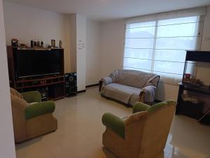 a living room with two chairs and a flat screen tv at Gran Vista in Fusagasuga