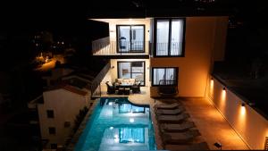 a house with a swimming pool at night at Villa Mavrem in Bezirgân