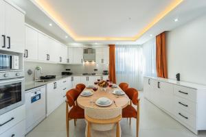 a kitchen with a table and chairs and a kitchen with white cabinets at Villa Mavrem in Bezirgân