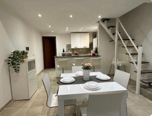 a kitchen and dining room with a white table and chairs at Mambo House in Milan