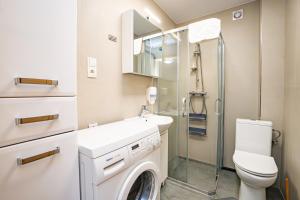 a bathroom with a washing machine and a sink at Dwie Sowy by Baltic Home in Międzyzdroje