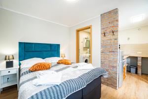 a bedroom with a large bed with orange pillows on it at Dwie Sowy by Baltic Home in Międzyzdroje