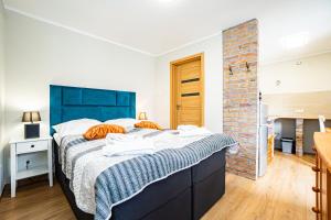 a bedroom with a large bed with a blue headboard at Dwie Sowy by Baltic Home in Międzyzdroje