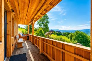 a wooden porch with a view of the mountains at Casa WEZLY 2 in Măgura