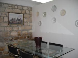 a glass table in a room with a stone wall at Dammuso Bouganville in Scicli