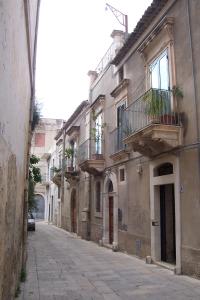 an alley in an old building with potted plants at Dammuso Bouganville in Scicli