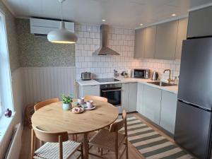 a kitchen with a table and chairs and a refrigerator at Lönngården in Kristinestad