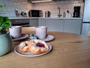 a table with two plates of pastries and two cups at Lönngården in Kristinestad