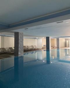 a swimming pool with chairs in a building at Mirage Hotel & SPA - Struga in Struga