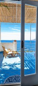 a door to a room with a view of the ocean at Casa Intiso - Two double bedroom apartment in Positano