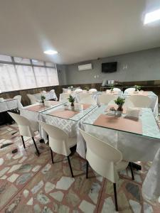ein Konferenzraum mit Tischen und weißen Stühlen in der Unterkunft Hotel Picpo in Ponte Nova