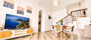 a living room with a flat screen tv on a wall at Casa Intiso - Two double bedroom apartment in Positano