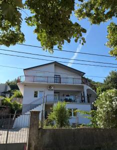 a white house with a balcony on the side of it at B&B Ana in Virpazar