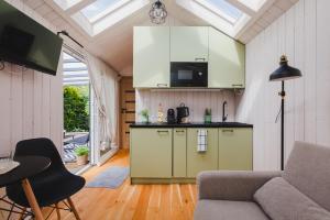 a kitchen with white cabinets and a couch in a room at Tiny House in Mechelinki +18 photos