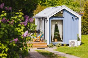 a blue shed with a deck in a garden at Tiny House in Mechelinki