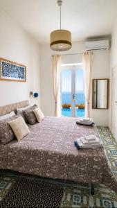 a bedroom with a large bed with a view of the ocean at Casa Intiso - Two double bedroom apartment in Positano +26 photos