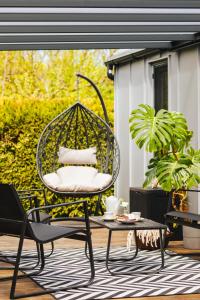 a patio with a swing chair and a table at Tiny House in Mechelinki
