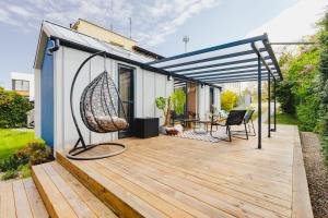 a deck with a swing and a house at Tiny House in Mechelinki