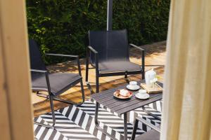 two chairs and a table with a plate of food on a patio at Tiny House in Mechelinki