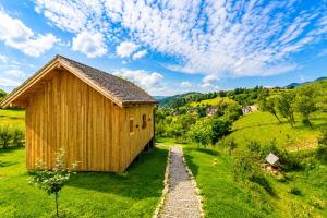 ein Holzgebäude auf einem grasbewachsenen Hügel mit einem Weg in der Unterkunft Wezly Tiny House in Măgura
