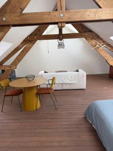 a bedroom with a bed and a table and chairs at Le Studio in Milly-sur-Thérain