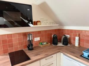 a kitchen with a counter top with a microwave at Le Studio in Milly-sur-Thérain
