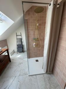 a shower with a glass door in a bathroom at Le Studio in Milly-sur-Thérain