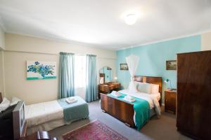 a hotel room with two beds and a television at Tulbagh Travelers Lodge - Cape Dutch Quarters in Tulbagh