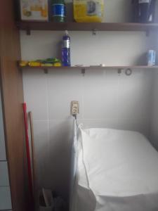 a room with a bed in a room with a shelf at Praia da Costa próx da Praia in Vila Velha