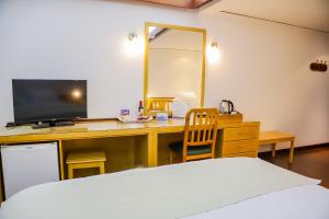 a bedroom with a bed and a desk with a television at Nobile Hotel Papillon in Bella Vista