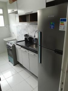 a kitchen with a stainless steel refrigerator and a sink at Praia da Costa próx da Praia in Vila Velha