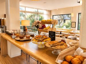 a table with bread and other food on it at The Originals Boutique Hôtel La Villa Ouest & Spa in Saint-Palais-sur-Mer