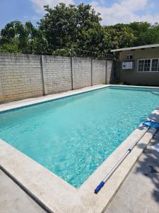 a swimming pool with blue water in a yard at Honey Beach House in La Esmeralda