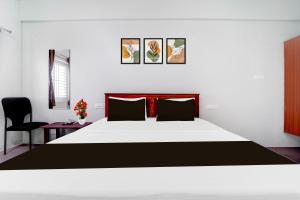 a bedroom with a large bed and a chair at Collection O Karumathampatti in Coimbatore