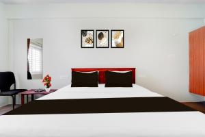 a bedroom with a large bed and a chair at Collection O Karumathampatti in Coimbatore +28 photos