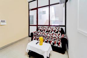 a living room with a couch and a table at Super Hotel O Okkilipalayam in Coimbatore