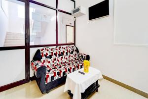 a living room with a couch and a table at Super Hotel O Okkilipalayam in Coimbatore