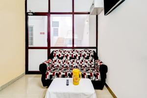 a living room with a couch and a table at Super Hotel O Okkilipalayam in Coimbatore