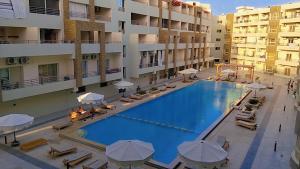 an overhead view of a swimming pool with chairs and umbrellas at Luxury Studio, pool, Private beach & close to Airport in Hurghada