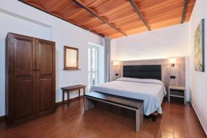 a bedroom with a white bed and a wooden ceiling at Albergo Della Posta in Bracciano +102 photos