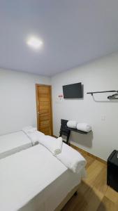 a hotel room with two beds and a flat screen tv at Hotel Luxx Sorriso in Sorriso