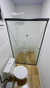 a white toilet in a room with a glass wall at Hotel Luxx Sorriso in Sorriso