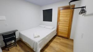 a bedroom with a bed and a desk and a television at Hotel Luxx Sorriso in Sorriso