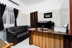 a office with a leather chair and a desk at Townhouse Coimbatore International Airport Formerly MK Elegance Inn in Coimbatore