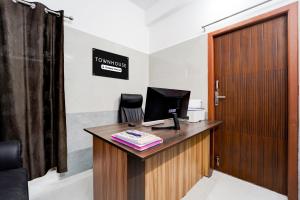 an office with a desk with a computer and a door at Townhouse Coimbatore International Airport Formerly MK Elegance Inn in Coimbatore