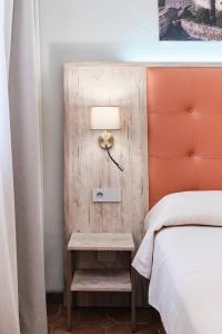 a bed room with a lamp on a table next to a bed at Albergo Della Posta in Bracciano