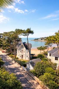 a view of a beach and a house and the ocean at The Originals Boutique Hôtel La Villa Ouest & Spa in Saint-Palais-sur-Mer