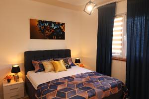 a bedroom with a bed with blue and yellow pillows at Apartman Boki in Bileća